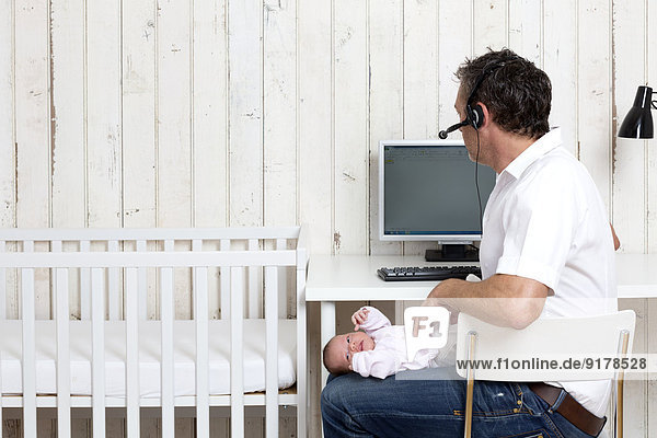 Man at home office with his baby