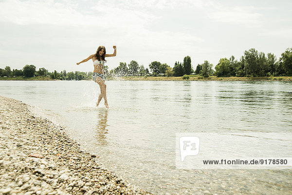Young woman running at waterside of Rhine river