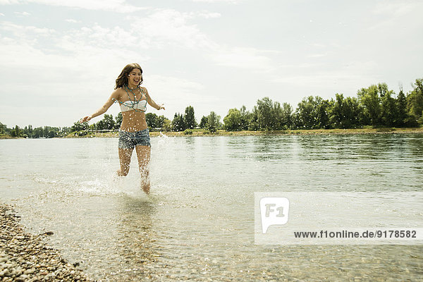 Junge Frau  die am Ufer des Rheins läuft