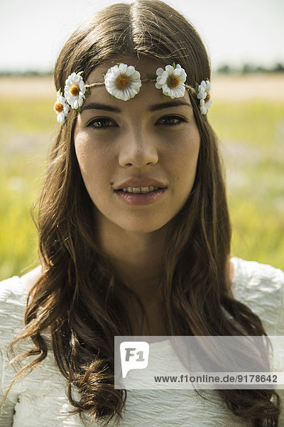 Porträt einer jungen Frau mit Blumenkranz