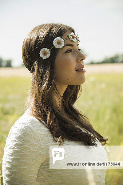 Porträt einer jungen Frau mit Blumenkranz