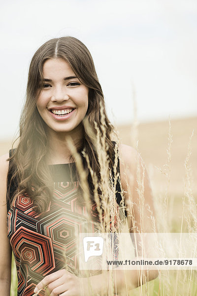 Porträt einer glücklichen jungen Frau auf einer Herbstwiese