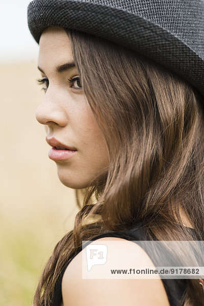 Porträt einer jungen Frau mit schwarzem Hut
