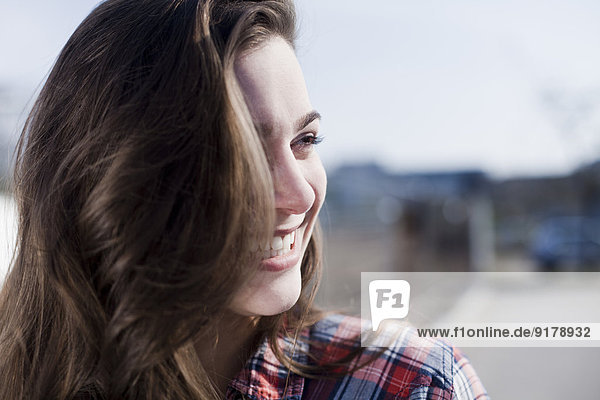 Lächelnde junge Frau im Freien