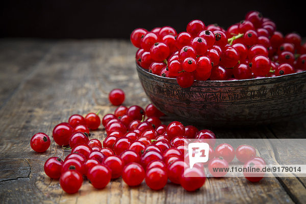 Schale mit roten Johannisbeeren  Ribes rubrum  auf dunklem Holztisch