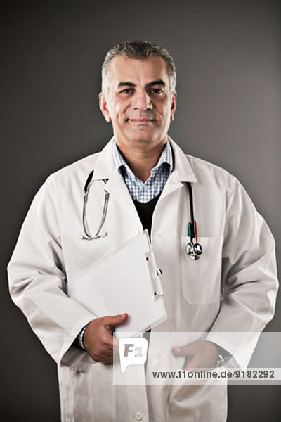 Portrait eines selbstbewussten Arztes mit Zwischenablage