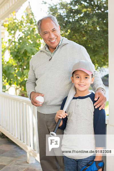 Portrait von Großvater und Enkel mit Baseball und Schläger