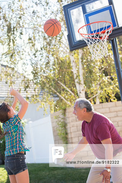 Großvater und Enkelin beim Basketballspielen