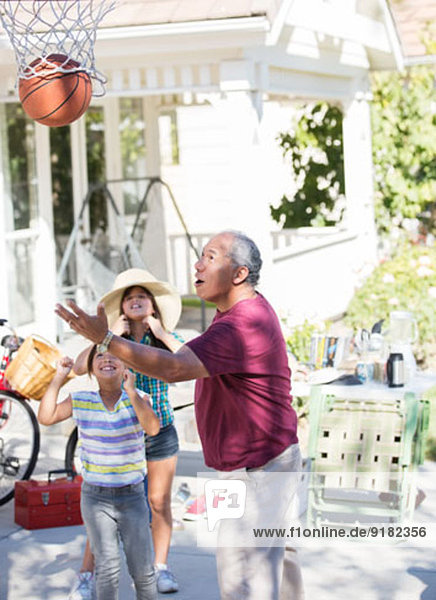 Großvater und Enkelinnen beim Basketballspielen