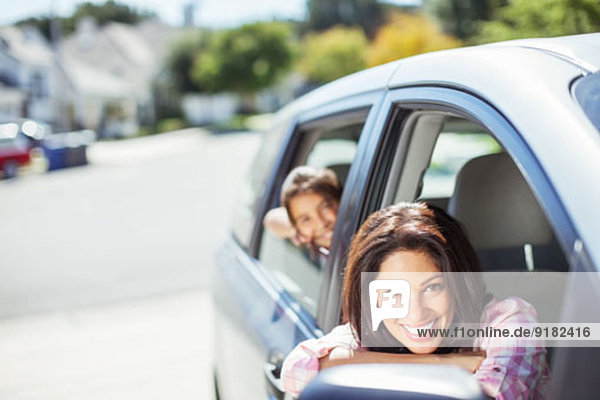 Porträt der lächelnden Mutter und Tochter im Auto