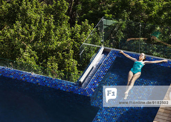 Frau schwimmt im Luxus-Schwimmbad