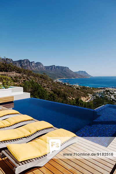 Liegestühle am Pool mit Blick auf den Ozean