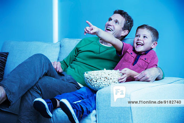 Vater und Sohn beim Fernsehen im Wohnzimmer