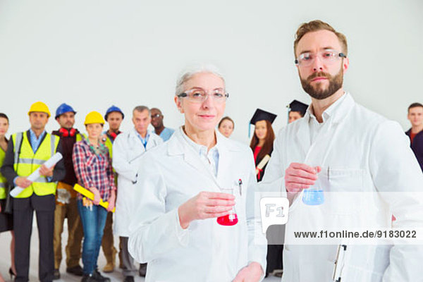 Portrait von Wissenschaftlern mit Mitarbeitern im Hintergrund