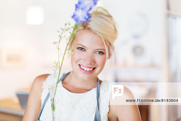 Frau mit Blume in rustikaler Küche