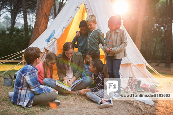 Lehrer und Schüler beim Lesen auf dem Campingplatz