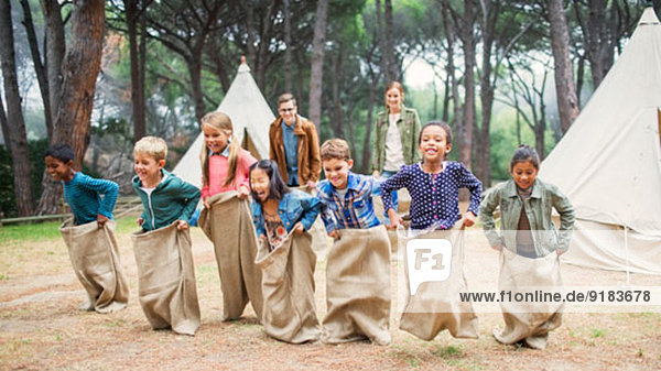 Kinder beim Sackhüpfen auf dem Campingplatz