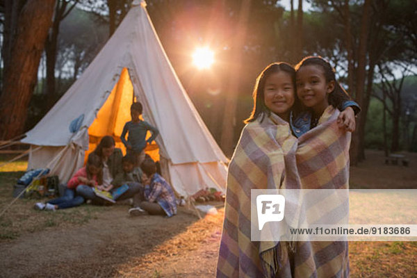 Mädchen in Decke gewickelt auf dem Campingplatz