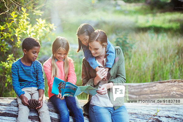 Schüler und Lehrer lesen Karte im Wald