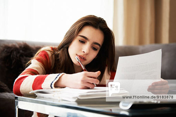 Girl doing homework at coffee table
