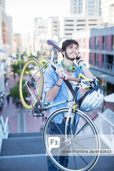 Mann mit Fahrrad auf Stadttreppe