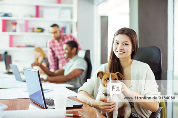 Woman petting dog in office