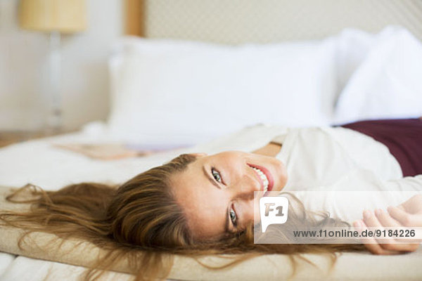Geschäftsfrau im Hotelzimmer auf dem Bett liegend