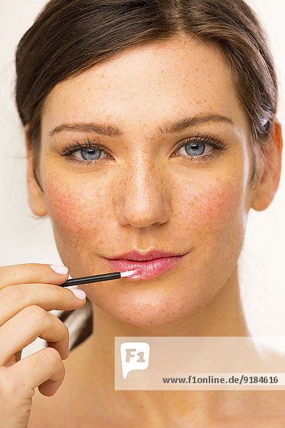 Caucasian woman applying makeup