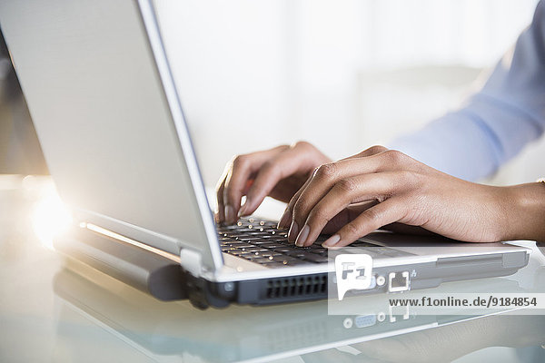 Mixed race businesswoman working on laptop