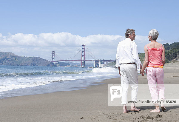 Senior Caucasian couple walking by Golden Gate Bridge  San Francisco  California  United States