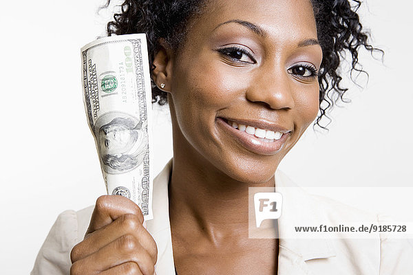 African American woman holding hundred dollar bill