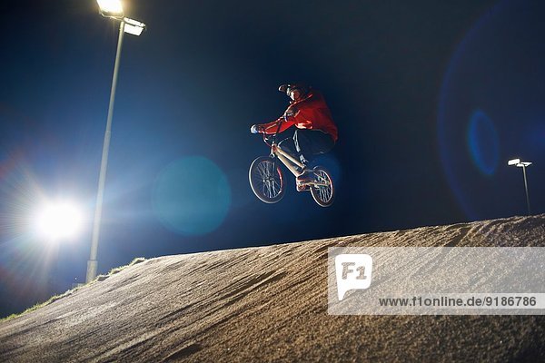 BMX-Radfahrer springt nachts auf sein Fahrrad