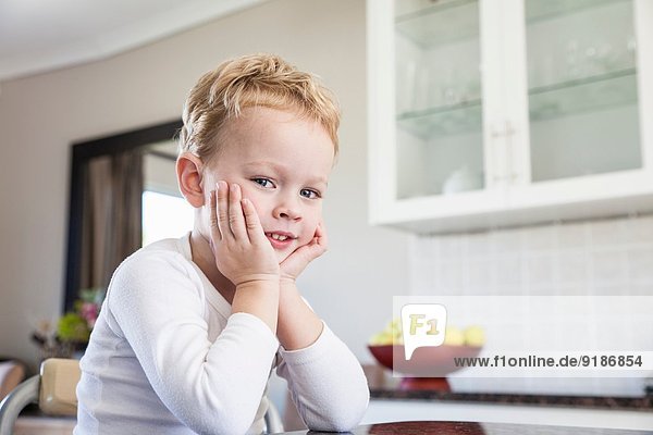 Porträt eines frechen vierjährigen Jungen in der Küche