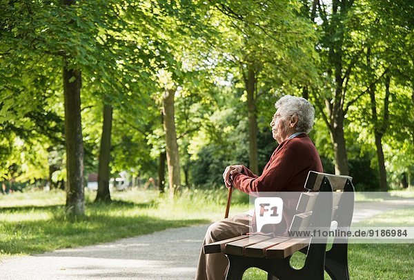 Seniorin auf Parkbank sitzend