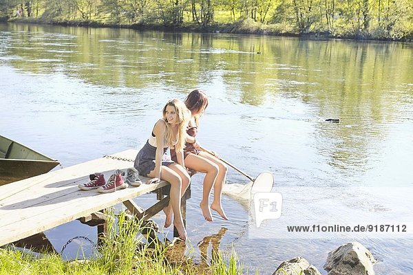 Young women sitting on jetty