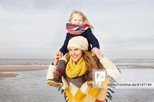 Mittlere erwachsene Frau Schulter tragende Tochter am Strand  Bloemendaal aan Zee  Niederlande