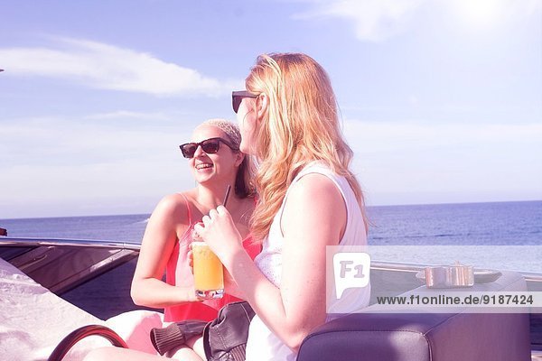 Zwei erwachsene Freundinnen lachen an Bord der Yacht