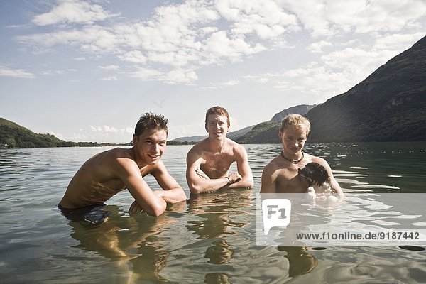 Portrait of three young adult men in lake
