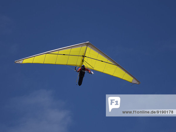 Low angle view of a person hang-gliding against sky