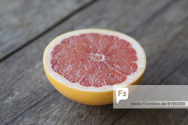 Close-up of pink grapefruit on wooden table