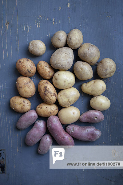 Verschiedene Kartoffeln auf Holztisch