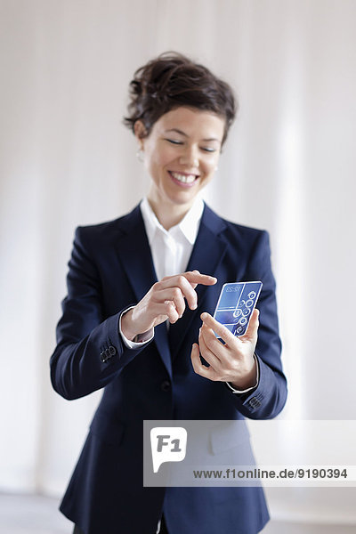 Glückliche Geschäftsfrau mit transparentem Smartphone