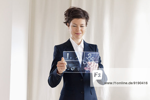 Porträt einer glücklichen Geschäftsfrau mit transparentem  futuristischem digitalem Tablett