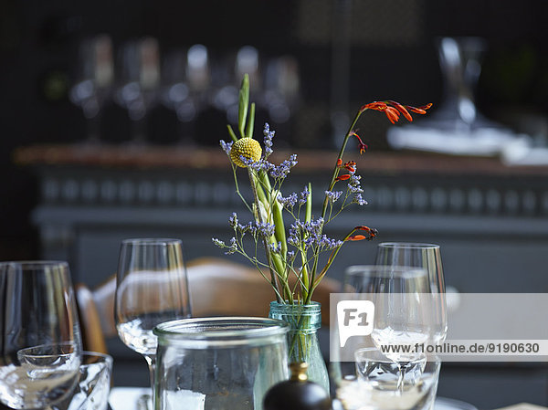 Blumenvase und Weingläser im Restaurant