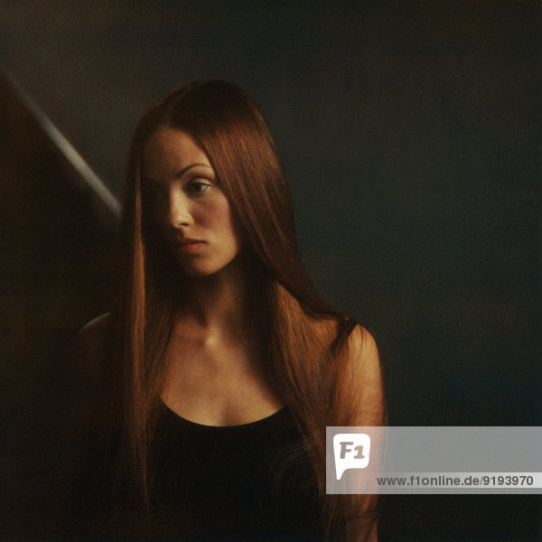 Woman with long hair  looking away sadly  portrait