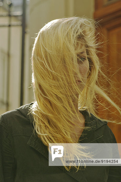 Frau mit langen blonden Haaren vom Wind zerzaust