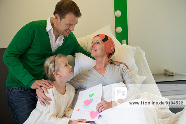 Girl with her father visiting to her mother in hospital