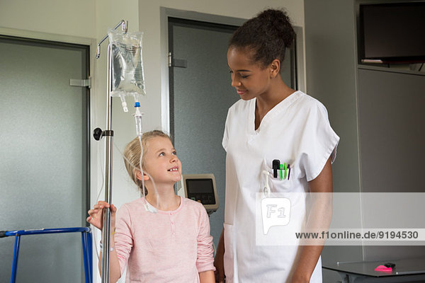 Female nurse assisting to a girl patient in hospital