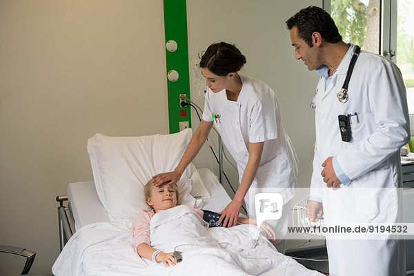 Ärztliche Begleitung bei der Untersuchung einer Patientin im Krankenhausbett