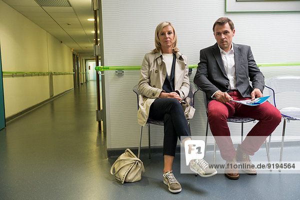 Paar im Wartebereich eines Krankenhauses sitzend
